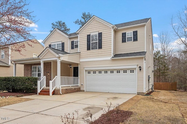 traditional-style house featuring a garage, a porch, concrete driveway, and fence