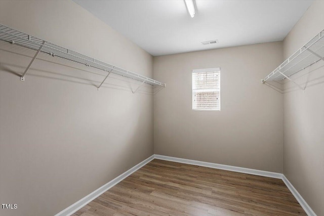 walk in closet featuring visible vents and wood finished floors