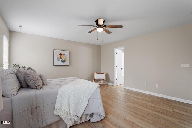 bedroom featuring baseboards, a ceiling fan, and light wood finished floors