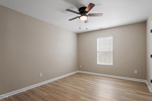 empty room featuring visible vents, light wood-style flooring, a ceiling fan, and baseboards