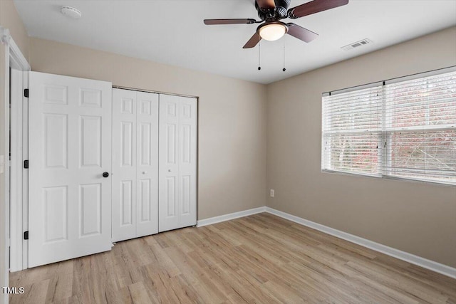 unfurnished bedroom with visible vents, a closet, light wood-style floors, baseboards, and ceiling fan