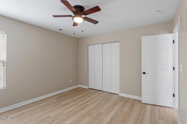 unfurnished bedroom with visible vents, a closet, light wood finished floors, baseboards, and ceiling fan