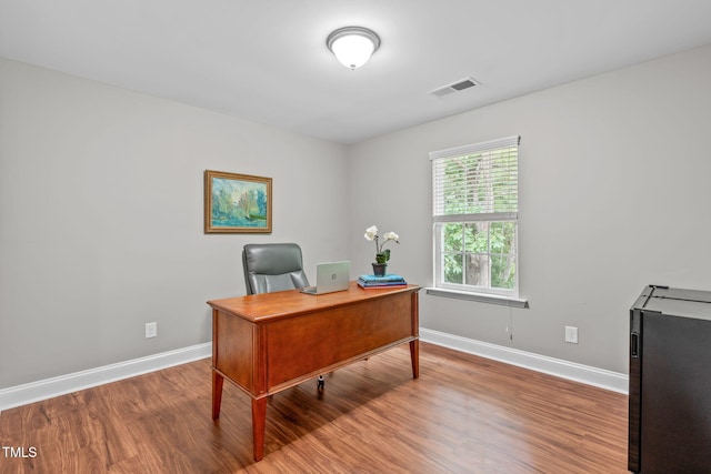 office space with visible vents, baseboards, and wood finished floors