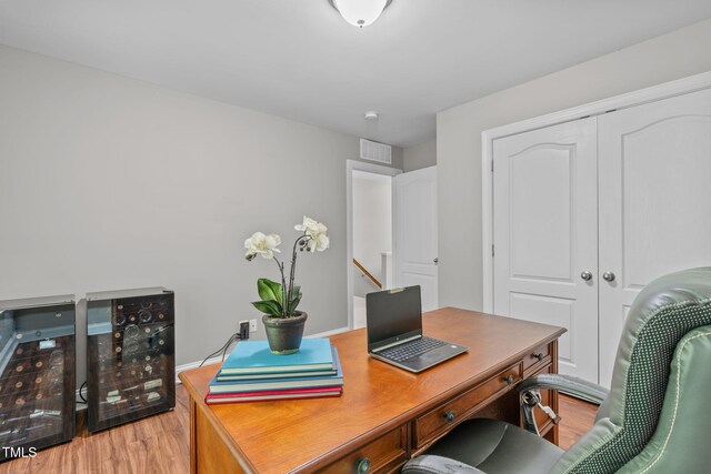 home office with visible vents, light wood-type flooring, and baseboards