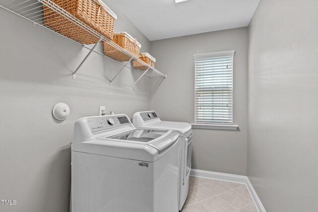 washroom featuring washer and dryer, baseboards, laundry area, and light tile patterned floors