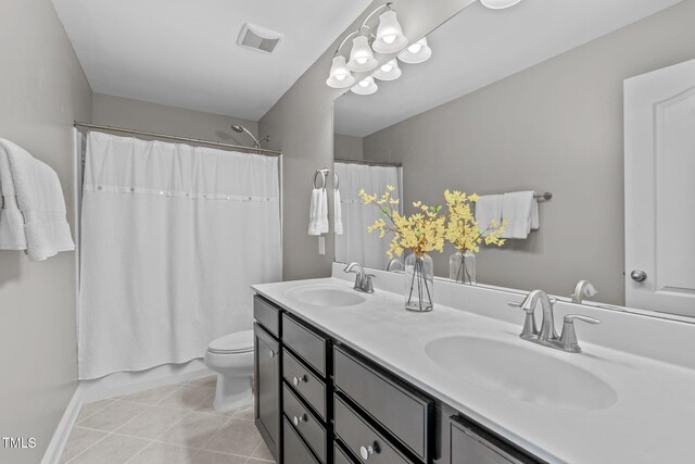 bathroom with a sink, visible vents, double vanity, and tile patterned flooring