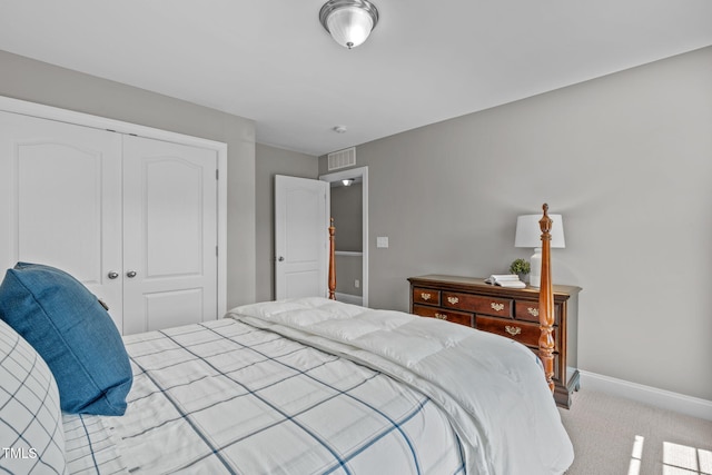 carpeted bedroom featuring a closet, visible vents, and baseboards