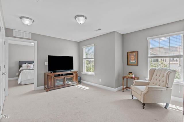 sitting room with visible vents, baseboards, and carpet flooring