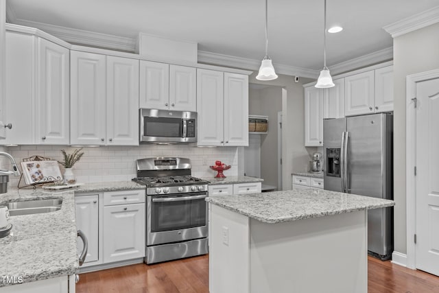 kitchen featuring a sink, stainless steel appliances, crown molding, and white cabinetry