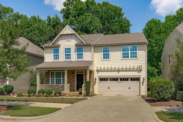 craftsman-style house with a garage, stone siding, covered porch, and concrete driveway