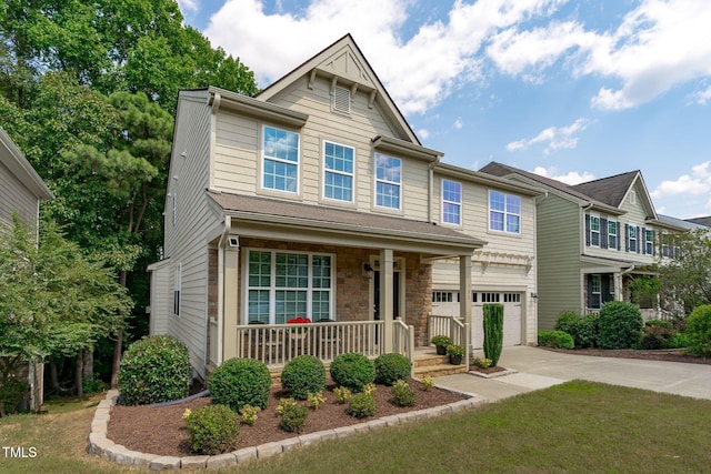 townhome / multi-family property with stone siding, covered porch, driveway, and an attached garage