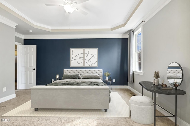 carpeted bedroom with a tray ceiling, baseboards, and crown molding