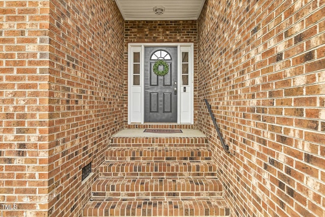 view of exterior entry featuring brick siding