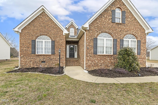 traditional-style home featuring a front yard, brick siding, and crawl space