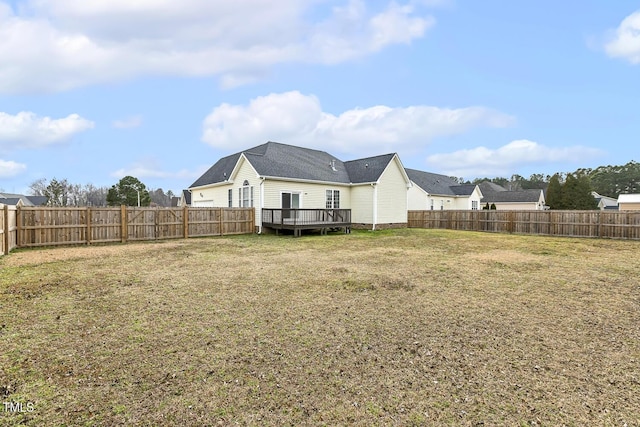 rear view of house with a fenced backyard, crawl space, a wooden deck, and a yard