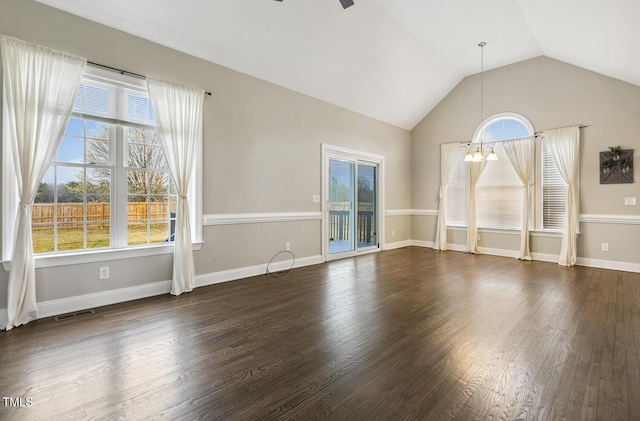 interior space featuring visible vents, baseboards, vaulted ceiling, ceiling fan with notable chandelier, and wood finished floors