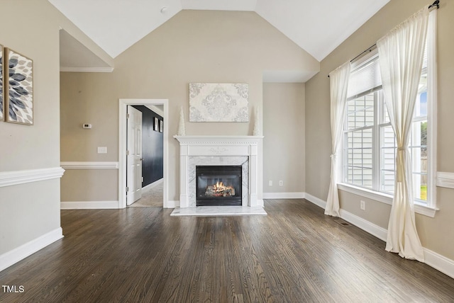 unfurnished living room with lofted ceiling, wood finished floors, baseboards, and a premium fireplace