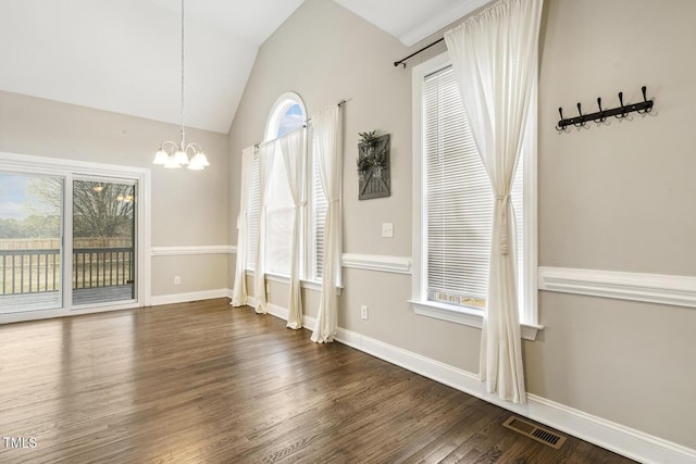 unfurnished dining area featuring visible vents, a healthy amount of sunlight, and vaulted ceiling