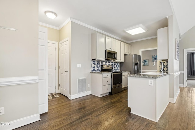 kitchen featuring visible vents, a sink, dark wood-type flooring, appliances with stainless steel finishes, and backsplash