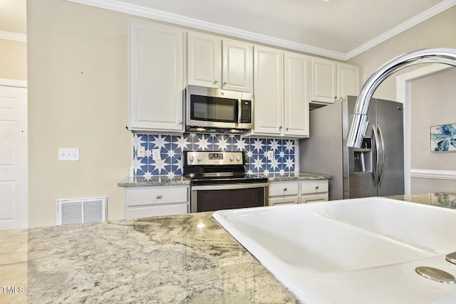 kitchen featuring decorative backsplash, ornamental molding, visible vents, and stainless steel appliances