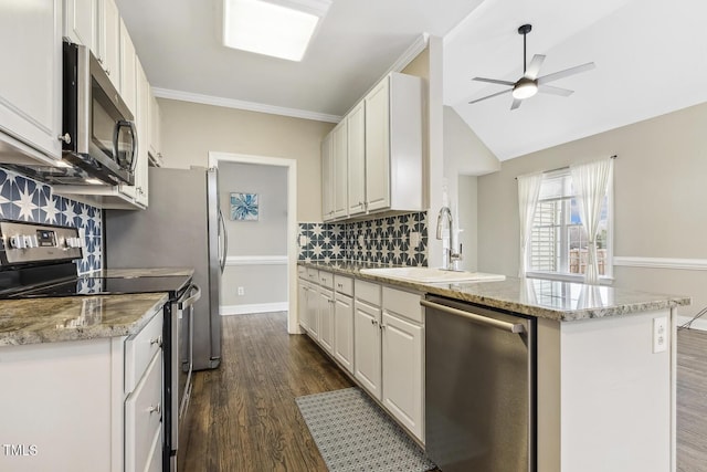 kitchen featuring dark wood-type flooring, appliances with stainless steel finishes, a peninsula, white cabinets, and a sink