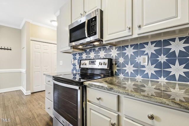 kitchen featuring baseboards, decorative backsplash, appliances with stainless steel finishes, crown molding, and light wood-type flooring