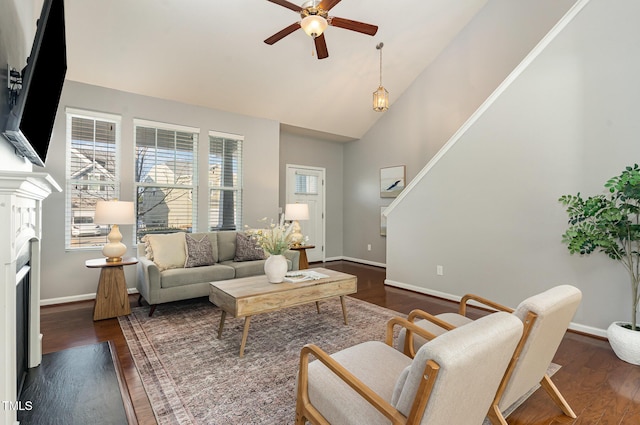 living room with high vaulted ceiling, a ceiling fan, wood finished floors, a fireplace, and baseboards