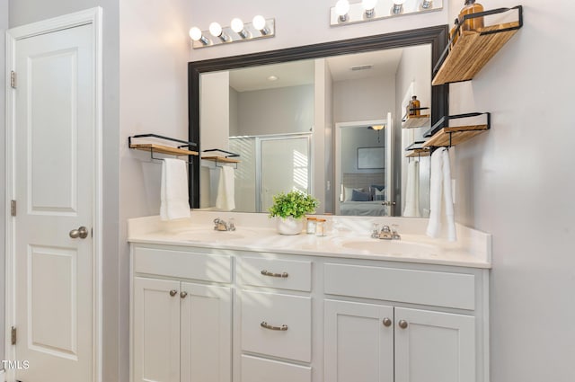 bathroom with double vanity, a stall shower, ensuite bathroom, and a sink