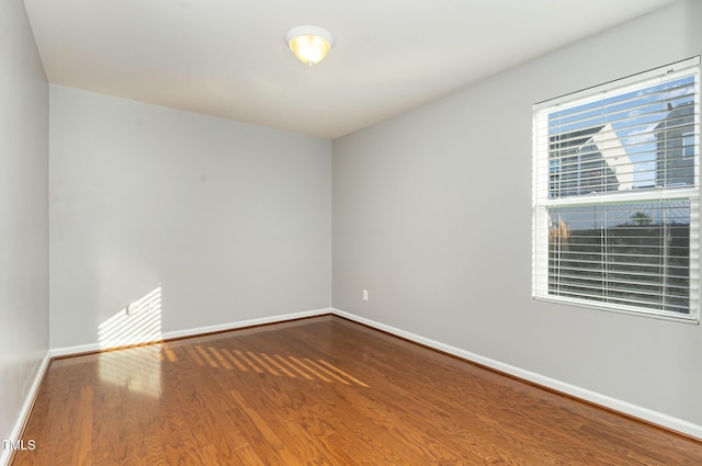 empty room with baseboards and wood finished floors