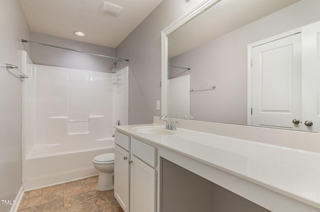 full bathroom with vanity, stone finish floor, toilet, and shower / washtub combination