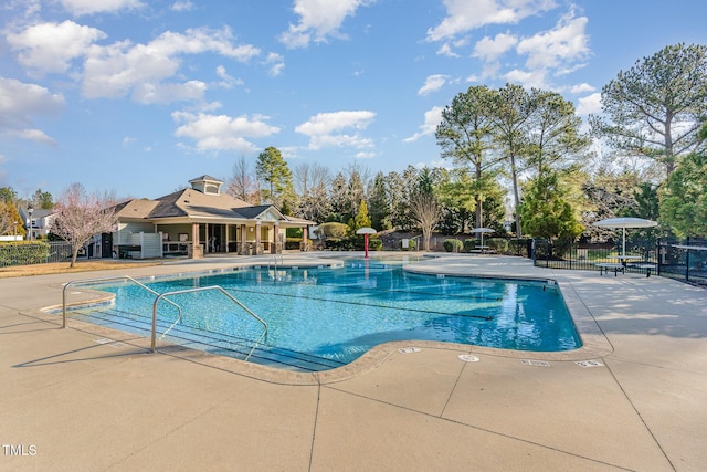 pool with a patio and fence