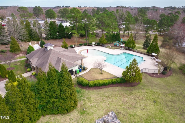 pool with a patio area, a lawn, and fence