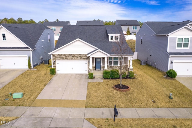 craftsman inspired home featuring a front yard, cooling unit, concrete driveway, stone siding, and a residential view