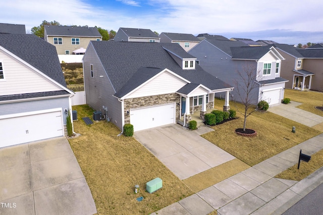 view of front of home with a residential view, driveway, a front lawn, and central AC