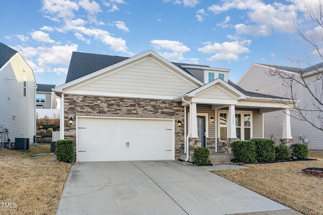 craftsman-style house featuring stone siding, a porch, concrete driveway, and an attached garage