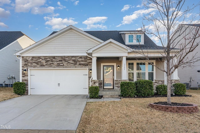 craftsman-style house with stone siding, driveway, a shingled roof, and a garage