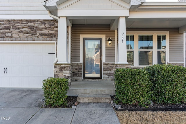 doorway to property with a garage and stone siding