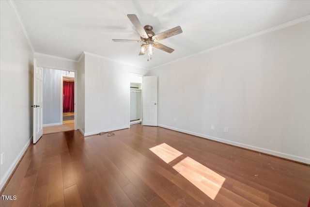 unfurnished bedroom with crown molding, wood finished floors, baseboards, and a closet