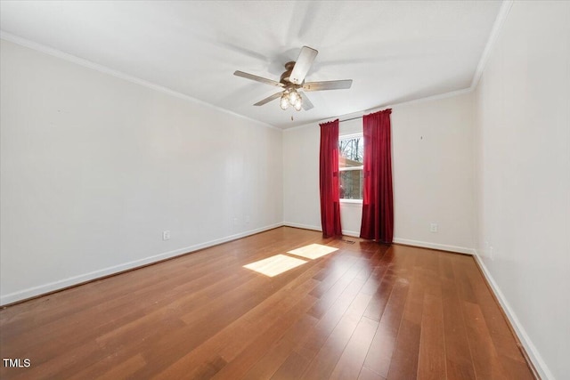 unfurnished room with ornamental molding, a ceiling fan, baseboards, and wood finished floors