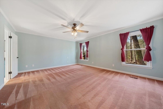 spare room with a wealth of natural light, carpet floors, and ornamental molding