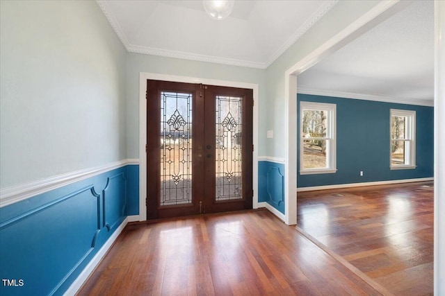 foyer entrance featuring french doors, baseboards, wood finished floors, and crown molding