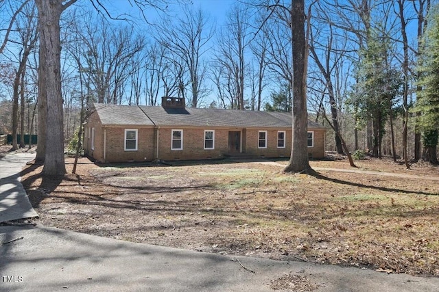 ranch-style house with brick siding and a chimney