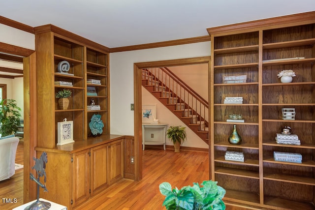 sitting room featuring stairs, crown molding, and light wood finished floors