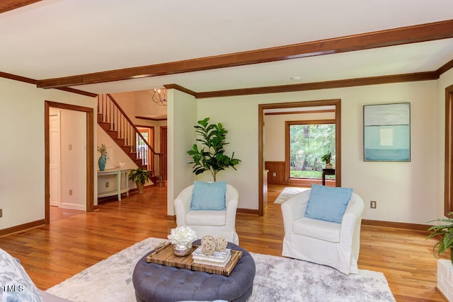 living room with an inviting chandelier, beamed ceiling, wood finished floors, and baseboards