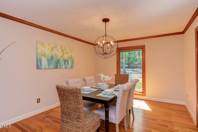 dining space featuring light wood finished floors, an inviting chandelier, crown molding, and baseboards