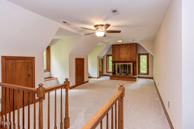 additional living space featuring baseboards, visible vents, light carpet, and lofted ceiling