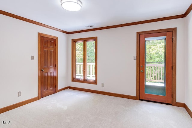 carpeted spare room with visible vents, plenty of natural light, and crown molding