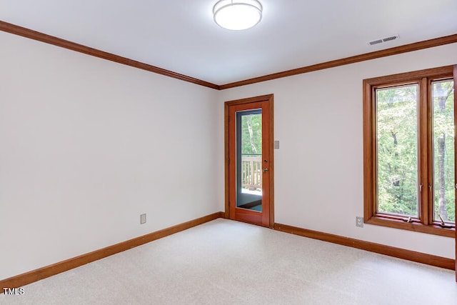 empty room featuring crown molding, visible vents, baseboards, and light carpet