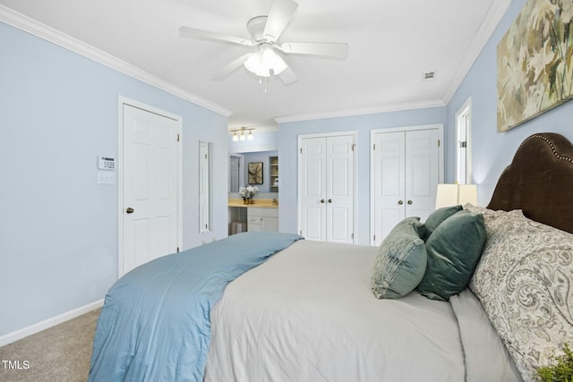 bedroom with visible vents, two closets, crown molding, and carpet