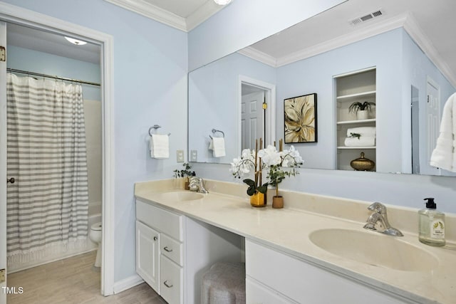 bathroom featuring a sink, visible vents, toilet, and ornamental molding